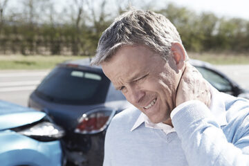 man holding neck after car accident